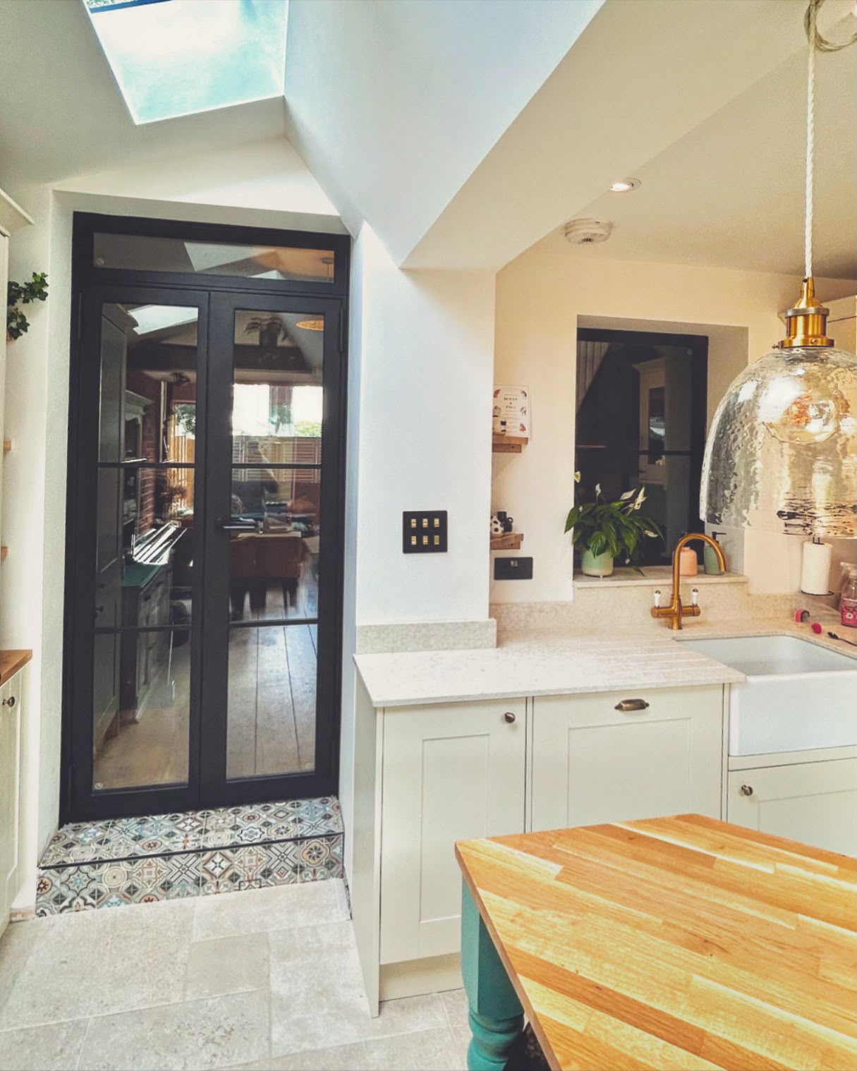 Black Steel Internal Double Doors Kitchen Black steel internal double doors with glazed panels and an overhead pane beside cream kitchen cabinets.